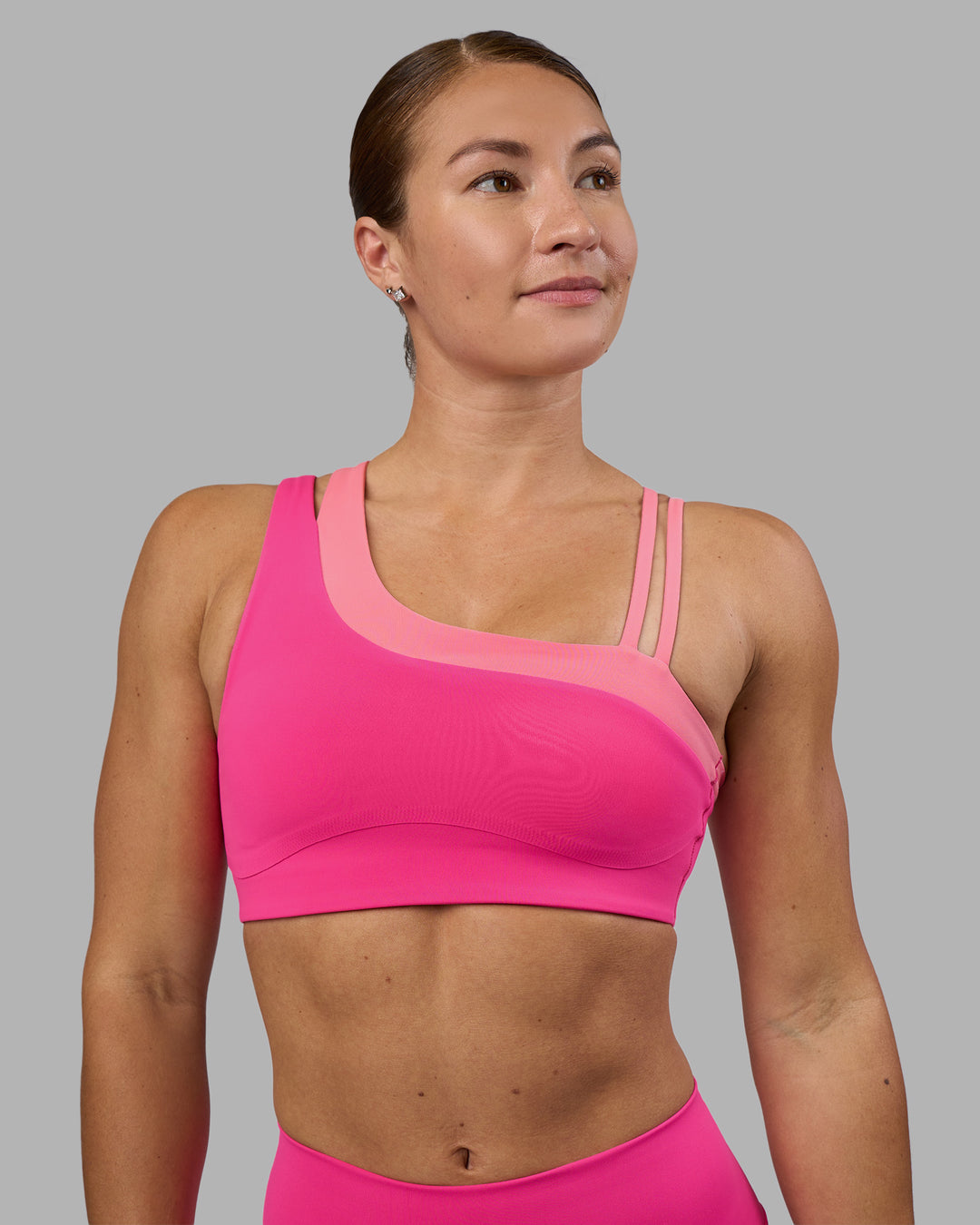 Woman wearing Thrive Asymmetric Sports Bra - Ultra Pink-Candy Pink | Model:Hannah | Size:S - view 1
