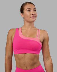 Woman wearing Thrive Asymmetric Sports Bra - Ultra Pink-Candy Pink | Model:Hannah | Size:S | Thumbnail Index: 0