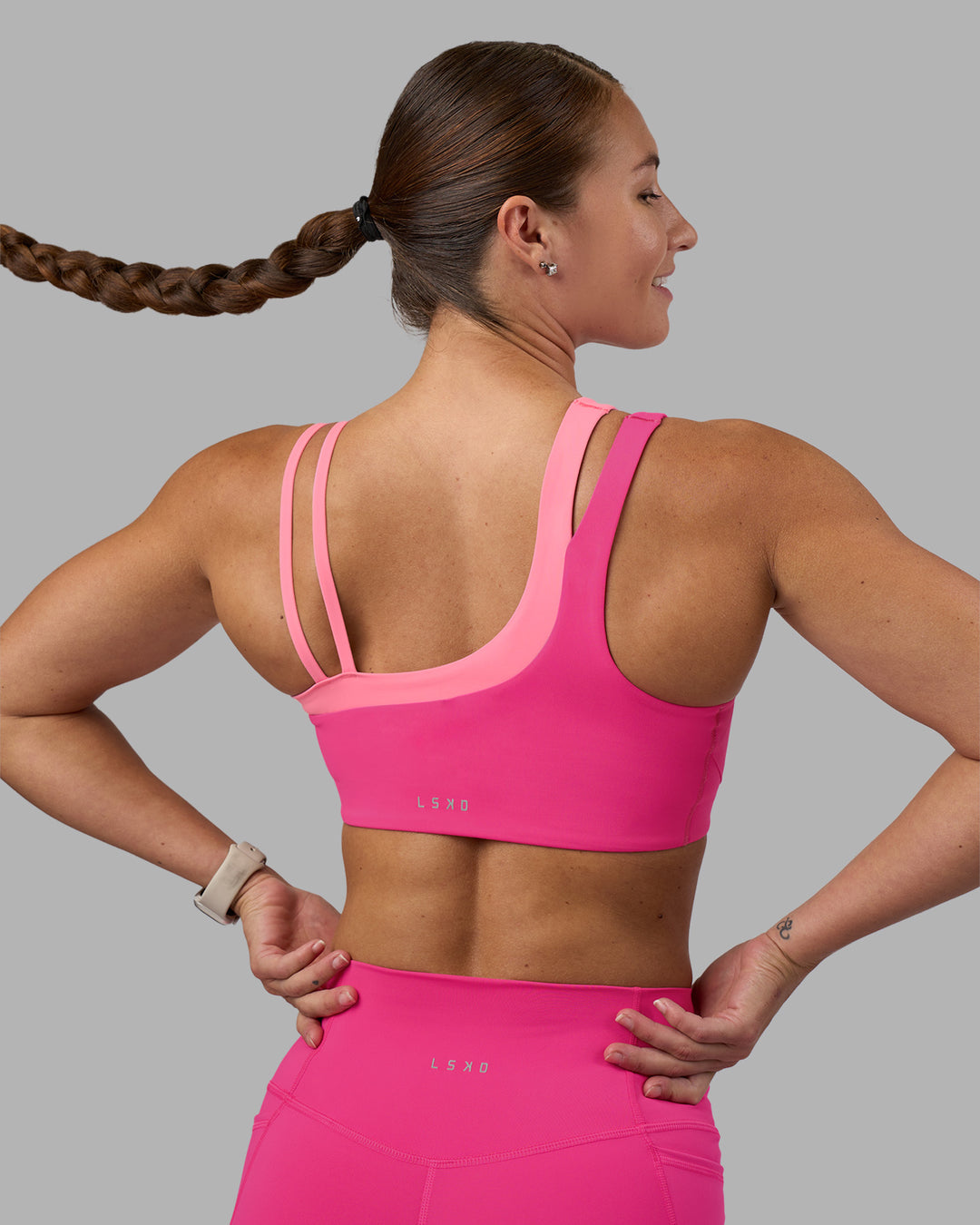 Woman wearing Thrive Asymmetric Sports Bra - Ultra Pink-Candy Pink | Model:Hannah | Size:S - view 2
