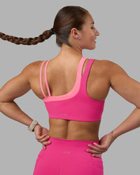 Woman wearing Thrive Asymmetric Sports Bra - Ultra Pink-Candy Pink | Model:Hannah | Size:S | Thumbnail Index: 1