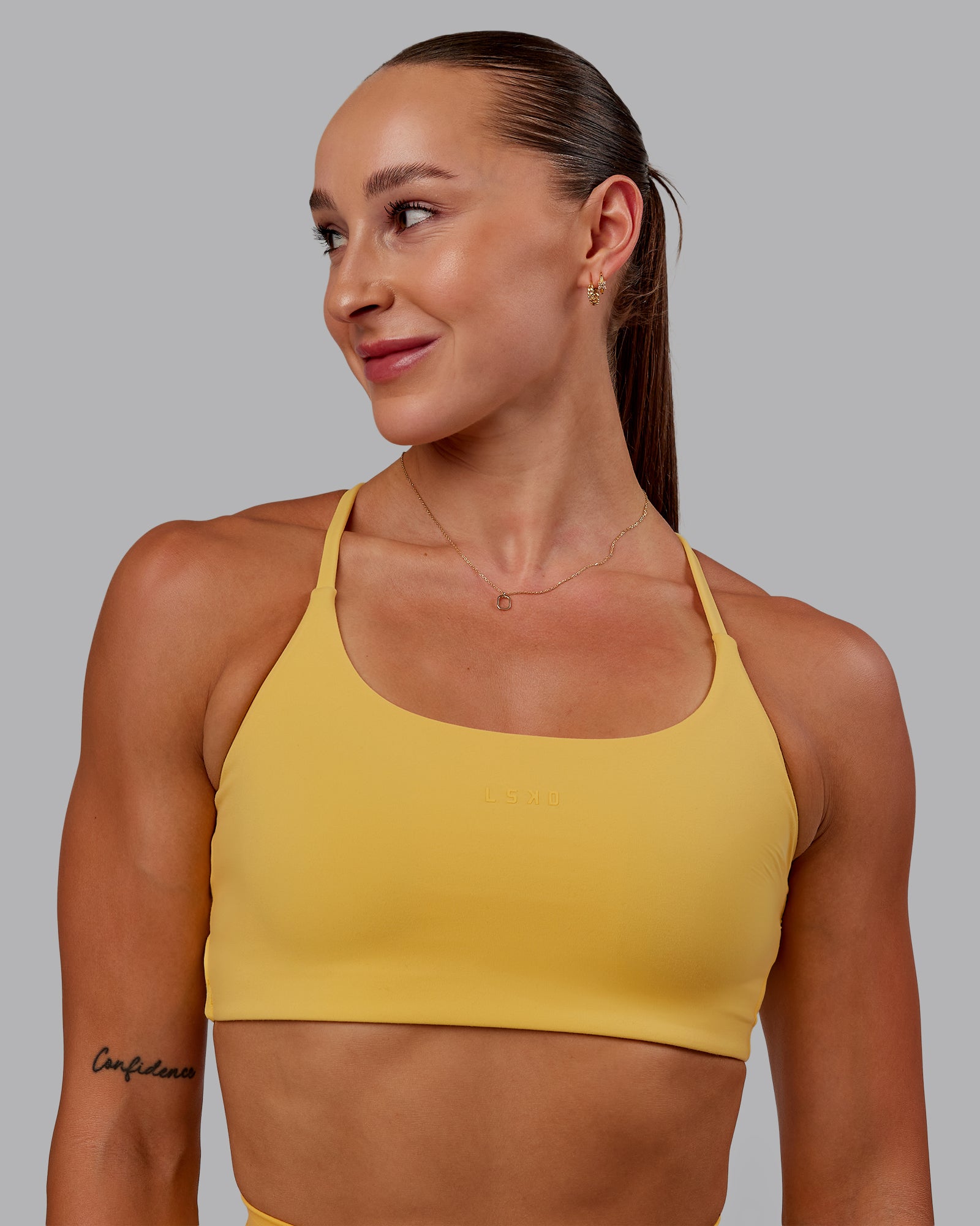 Woman wearing Twist Sports Bra in Banana Cream | Size:S