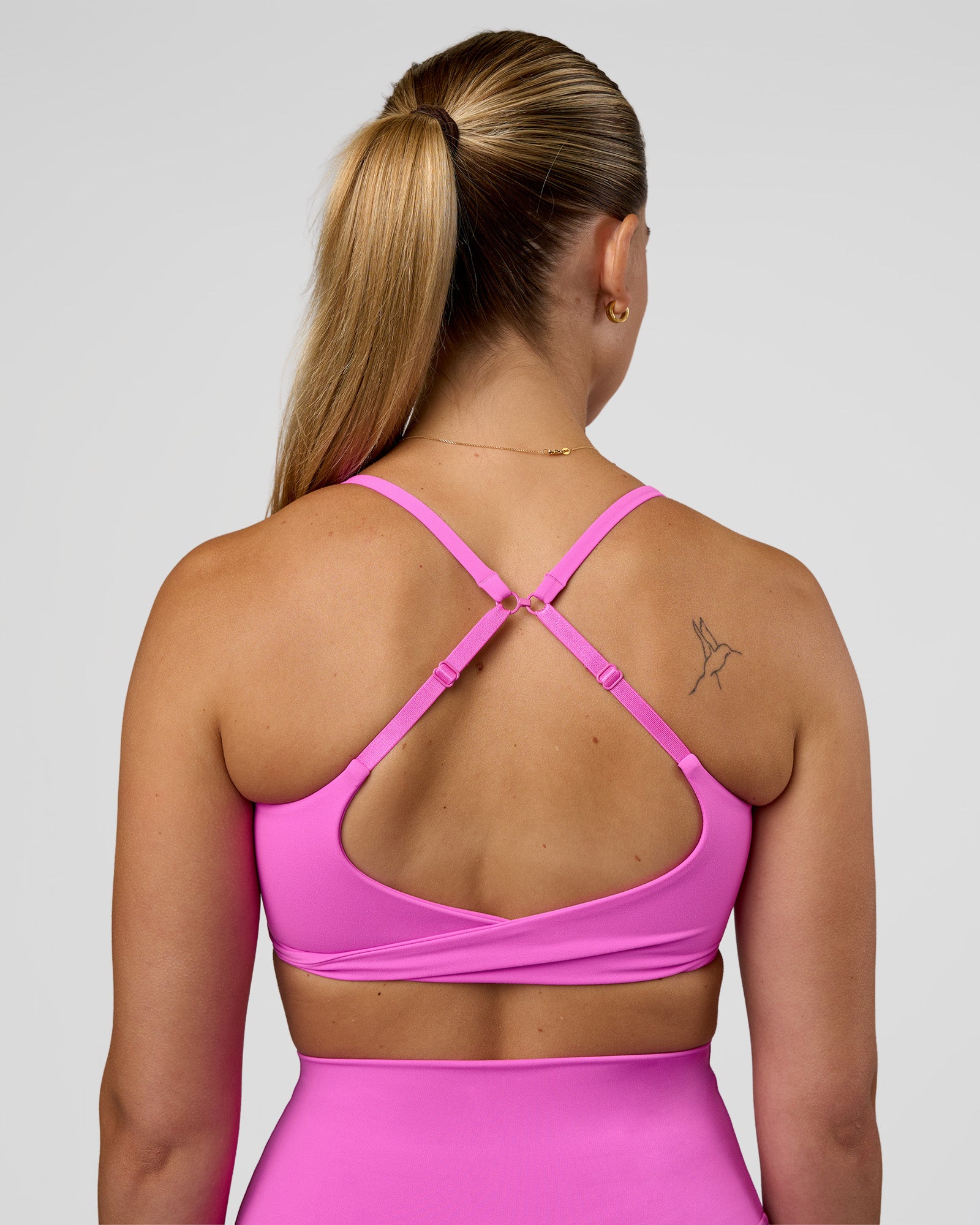 Woman wearing Twist Sports Bra - Ultra Fuchsia | Model:Myrte | Size:S