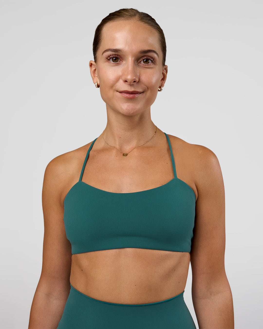 Woman wearing Twister Sports Bra - Transformative Teal | Model:Myrte | Size:S - view 1