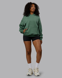 Woman wearing Unisex MVP Hoodie Oversize - Sage Brush | Thumbnail Index: 4
