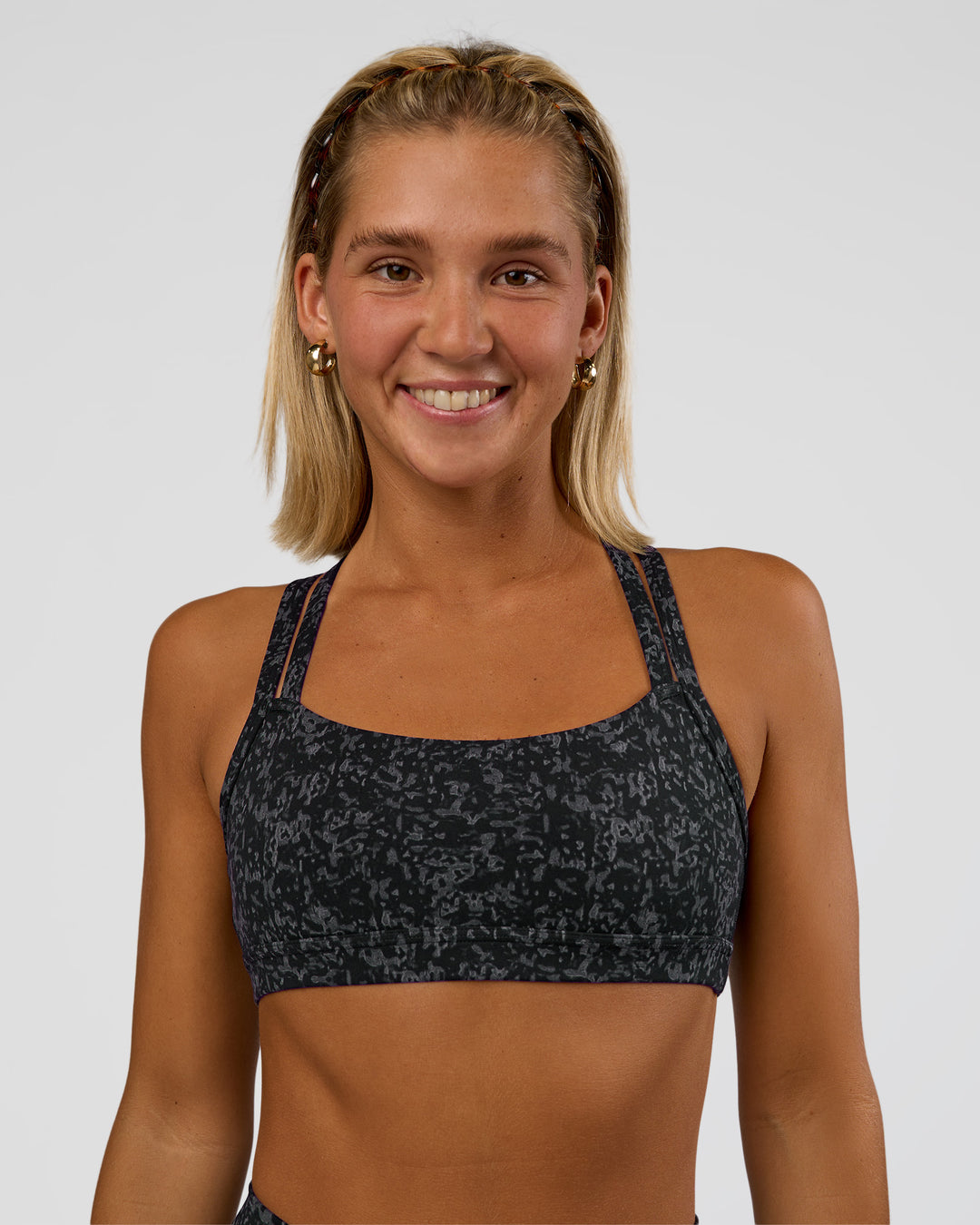 Woman wearing Velocity Sports Bra - Energy Print Black | Model:Amity | Size:S - view 2