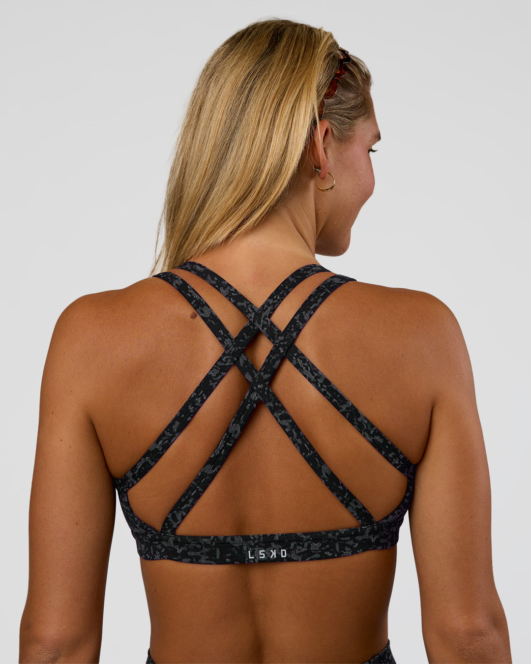 Woman wearing Velocity Sports Bra - Energy Print Black | Model:Amity | Size:S - view 1