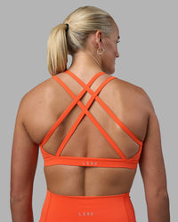 Woman wearing Velocity Sports Bra - Ultra Orange | Model:Katie | Size:S | Thumbnail Index: 0