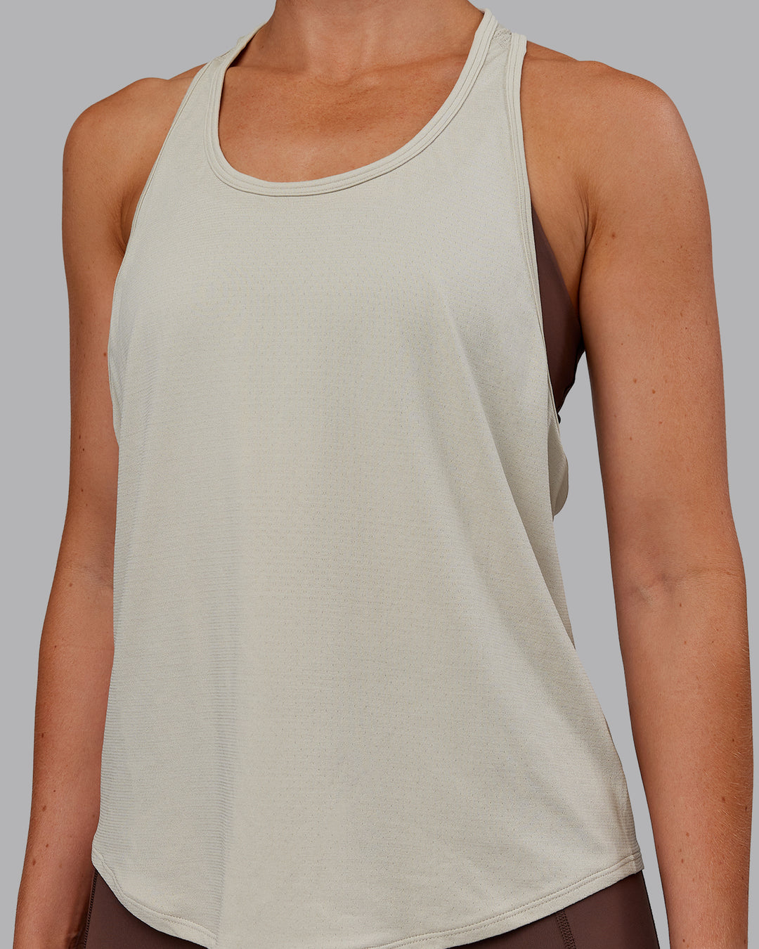 Woman wearing AeroFLX+ Drop Armhole Seamless Tank - Shale Beige | Model:Paris | Size:S - view 10