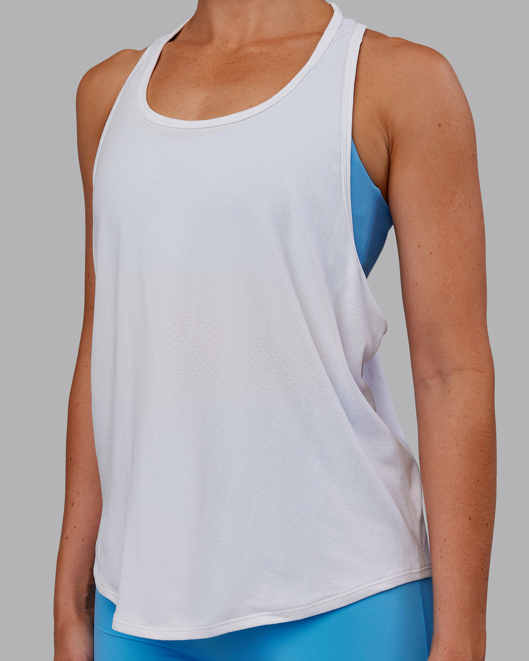 Woman wearing AeroFLX+ Drop Armhole Seamless Tank - White | Model:Paris | Size:S - view 3