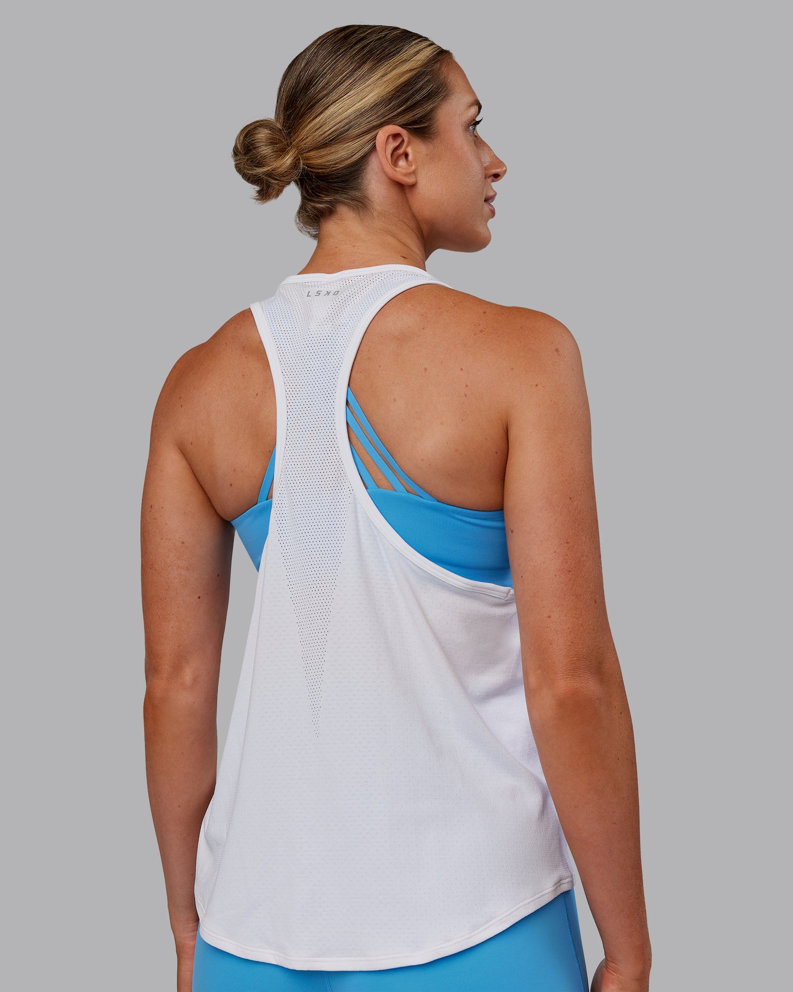 Woman wearing AeroFLX+ Drop Armhole Seamless Tank - White | Model:Paris | Size:S