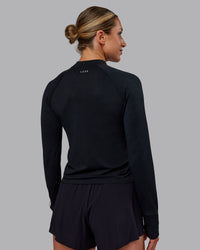 Woman wearing AeroFLX+ Long Sleeve Half Zip - Black Marl | Model:Paris | Size:S | Thumbnail Index: 3
