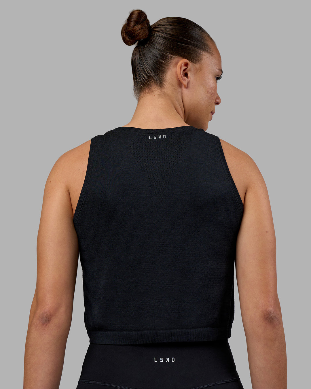 Woman wearing AeroFLX+ Seamless Skimmer Tank - Black Marl | Model:Charlize | Size:S - view 2