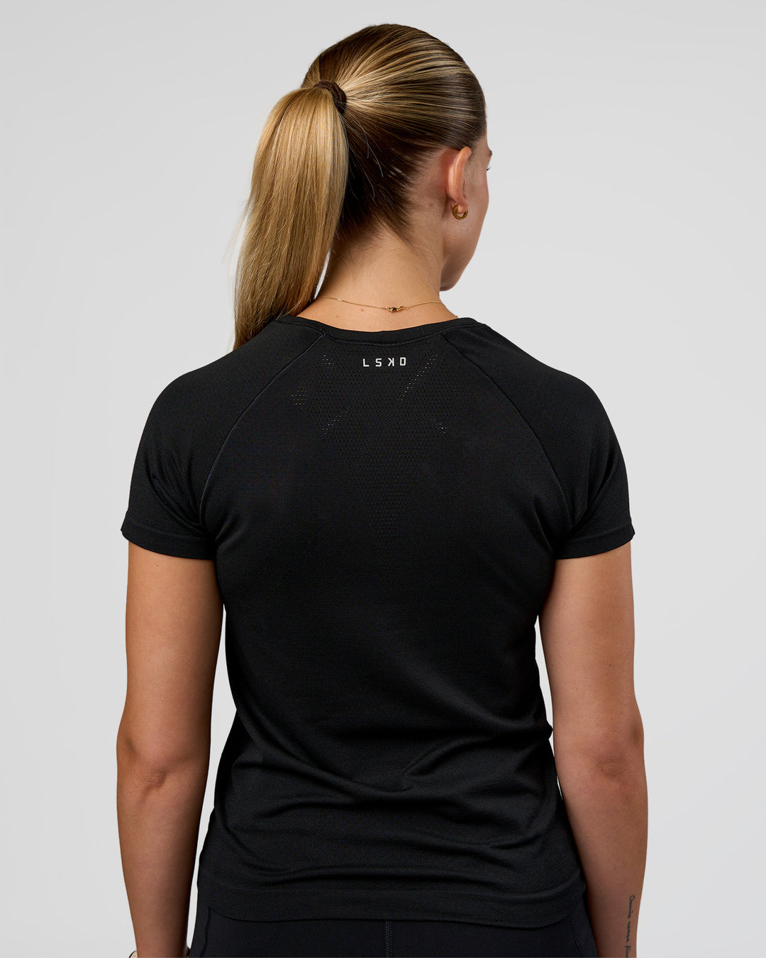 Woman wearing AeroFLX+ Seamless Tee - Black/Black | Model:Myrte | Size:S - view 3