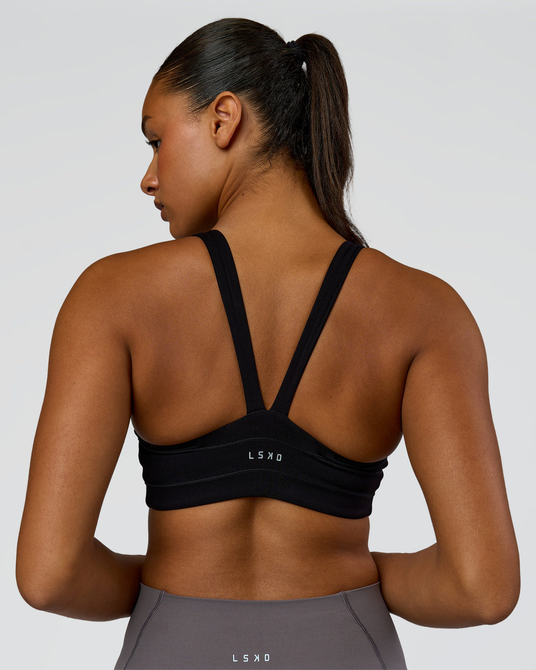Woman wearing Inertia Sports Bra - Black | Model:Rosie | Size:S - view 2