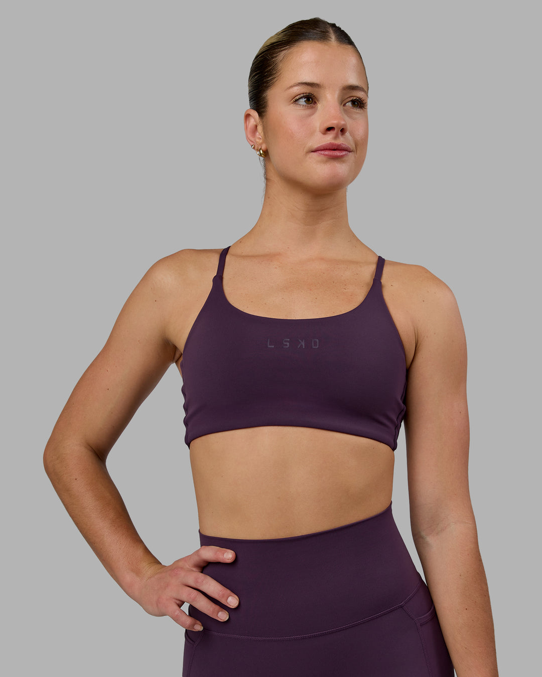 Woman wearing Twist Sports Bra - Midnight Plum - view 3