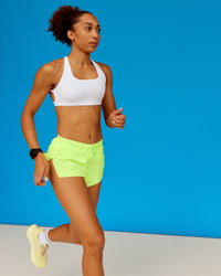 Woman wearing Accelerate 3" Running Short - Lime Glo | Model:Txai | Size:XS | Thumbnail Index: 4