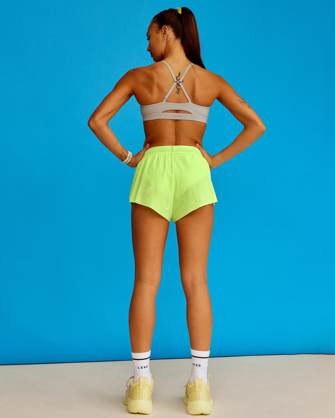 Woman wearing Accelerate 3" Running Short - Lime Glo-Shale Beige | Model:Steph | Size:XS - view 3