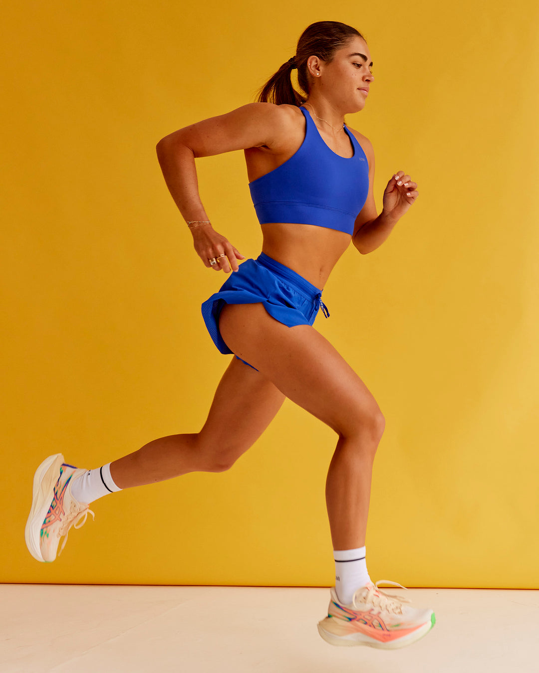 Woman wearing Accelerate Split Strap Sports Bra - Electric Indigo | Model:Bella | Size:XS - view 4