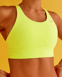 Woman wearing Accelerate Split Strap Sports Bra - Hyper Green | Model:Txai | Size:XS | Thumbnail Index: 1