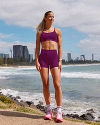 Woman wearing Elixir Defined High-Rise 4" Short - Plum Caspia | Model:Chloe | Size:XS | Thumbnail Index: 0