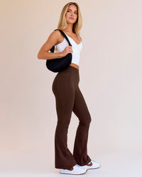 Woman wearing Fusion V-Contour High-Rise Flared Petite Legging Pockets - Hot Chocolate | Model:Issy | Size:XS | Thumbnail Index: 0