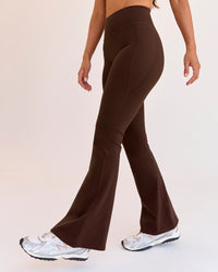 Woman wearing Fusion V-Contour High-Rise Flared Petite Legging Pockets - Hot Chocolate | Model:Brylee | Size:XS | Thumbnail Index: 1