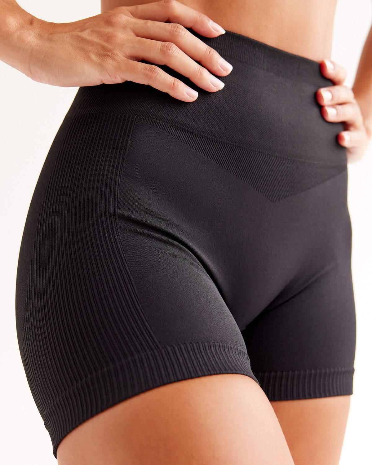 Woman wearing Surge Seamless High-Rise 4" Short - Black | Model:Brylee | Size:XS
