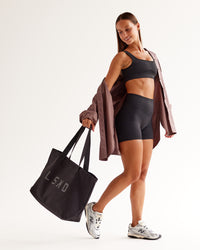 Woman wearing Surge Seamless High-Rise 4" Short - Black | Model:Brylee | Size:XS | Thumbnail Index: 1