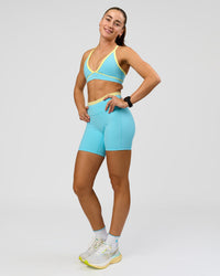 Woman wearing Lume Fusion Mid-Rise V Contour 6" Short Pockets - Baltic Sea-Lemon | Model:Grace | Size:XS | Thumbnail Index: 4