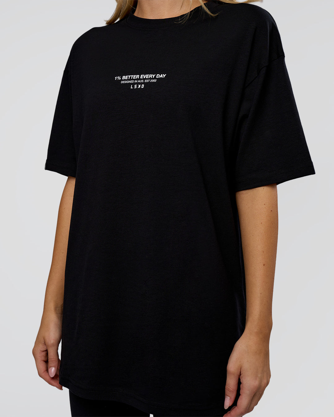 Woman wearing 1% Better Every Day EST FLXCotton Oversized Tee - Black | Model:Leilani | Size:XS - view 9