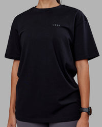 Woman wearing 1% Better Value Series FLXCotton Tee Oversize - Black-Black | Model:Rhiley | Size:XS | Thumbnail Index: 7