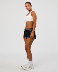 Woman wearing Accelerate 3" Reflective Mid-Rise Running Short - Black-Reflective | Model:Brylee | Size:XS | Thumbnail Index: 6