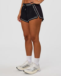 Woman wearing Accelerate 3" Reflective Mid-Rise Running Short - Black-Reflective | Set:true | Angle:side | Model:Brylee | Size:XS | Thumbnail Index: 5