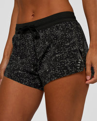 Woman wearing Accelerate 3" Mid-Rise Running Short - Energy Print Black | Set:true | Angle:closeup | Model:Brylee | Size:XS | Thumbnail Index: 0