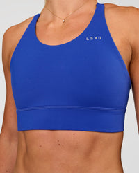 Woman wearing Accelerate Split Strap Sports Bra - Electric Indigo | Model:Emelia | Size:XS | Thumbnail Index: 5
