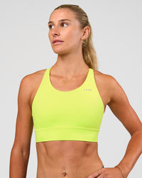Woman wearing Accelerate Split Strap Sports Bra - Hyper Green | Model:Emelia | Size:XS | Thumbnail Index: 3