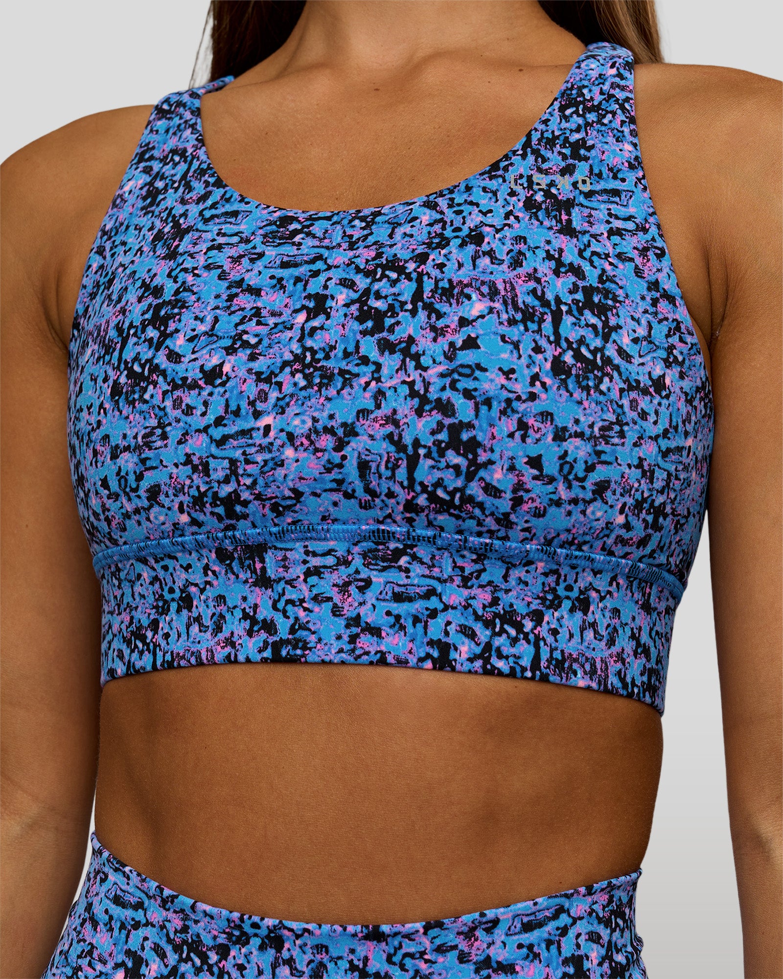 Woman wearing Accelerate Sports Bra in Energy Print Blue Multi | Model:Brylee | Size:XS