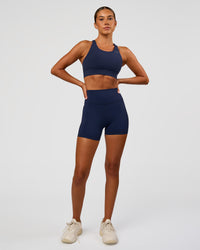 Woman wearing Accelerate Sports Bra - Future Navy | Model:Charlie | Size:XS | Thumbnail Index: 2