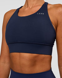 Woman wearing Accelerate Sports Bra - Future Navy | Model:Charlie | Size:XS | Thumbnail Index: 1