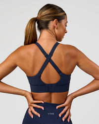 Woman wearing Accelerate Sports Bra - Future Navy | Model:Charlie | Size:XS | Thumbnail Index: 0