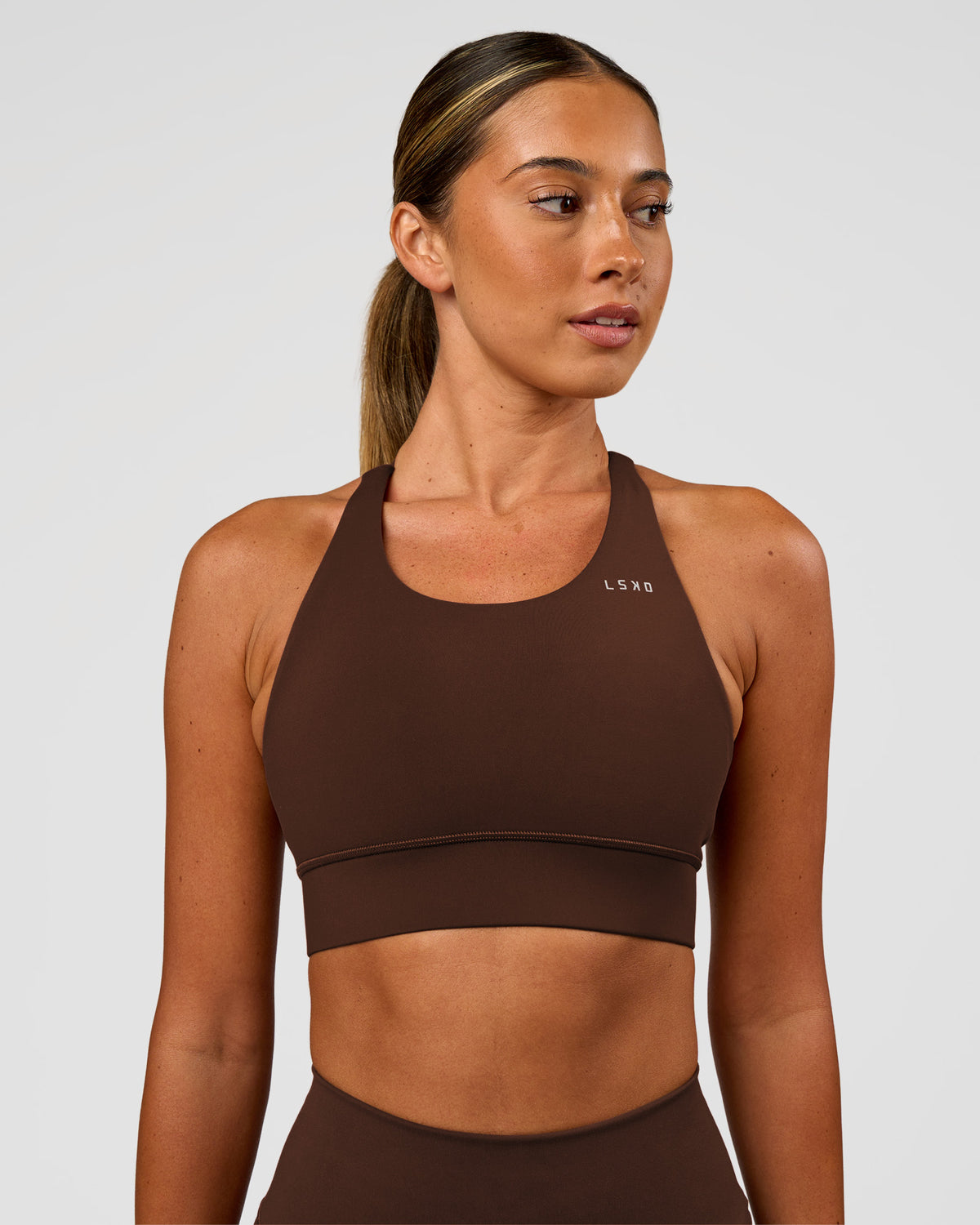 Woman wearing Accelerate Sports Bra - Hot Chocolate | Set:true | Angle:front | Model:Charli | Size:XS