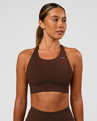 Woman wearing Accelerate Sports Bra - Hot Chocolate | Set:true | Angle:front | Model:Charli | Size:XS | Thumbnail Index: 0