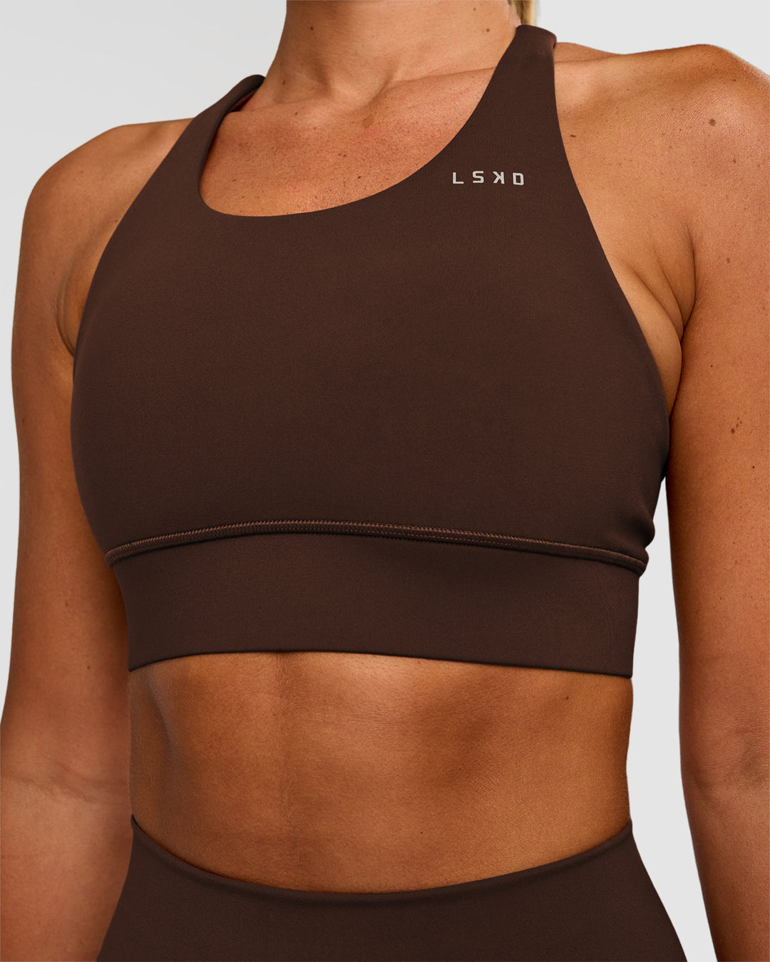 Woman wearing Accelerate Sports Bra - Hot Chocolate | Set:true | Angle:closeup | Model:Charli | Size:XS - view 6
