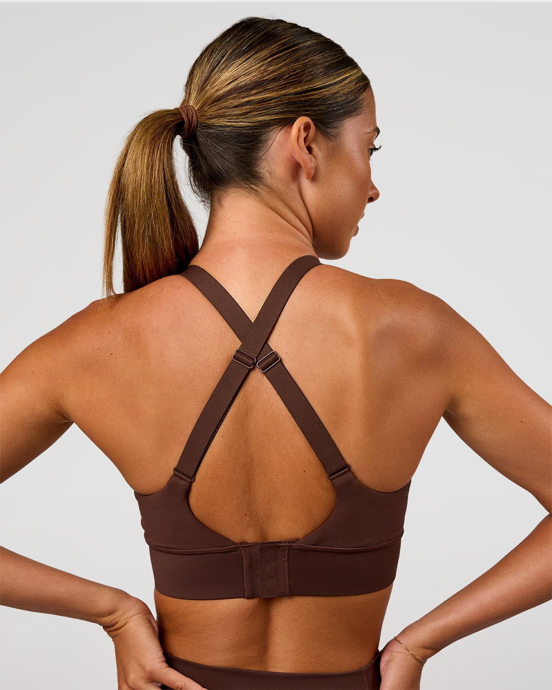 Woman wearing Accelerate Sports Bra - Hot Chocolate | Set:true | Angle:back | Model:Charli | Size:XS - view 2