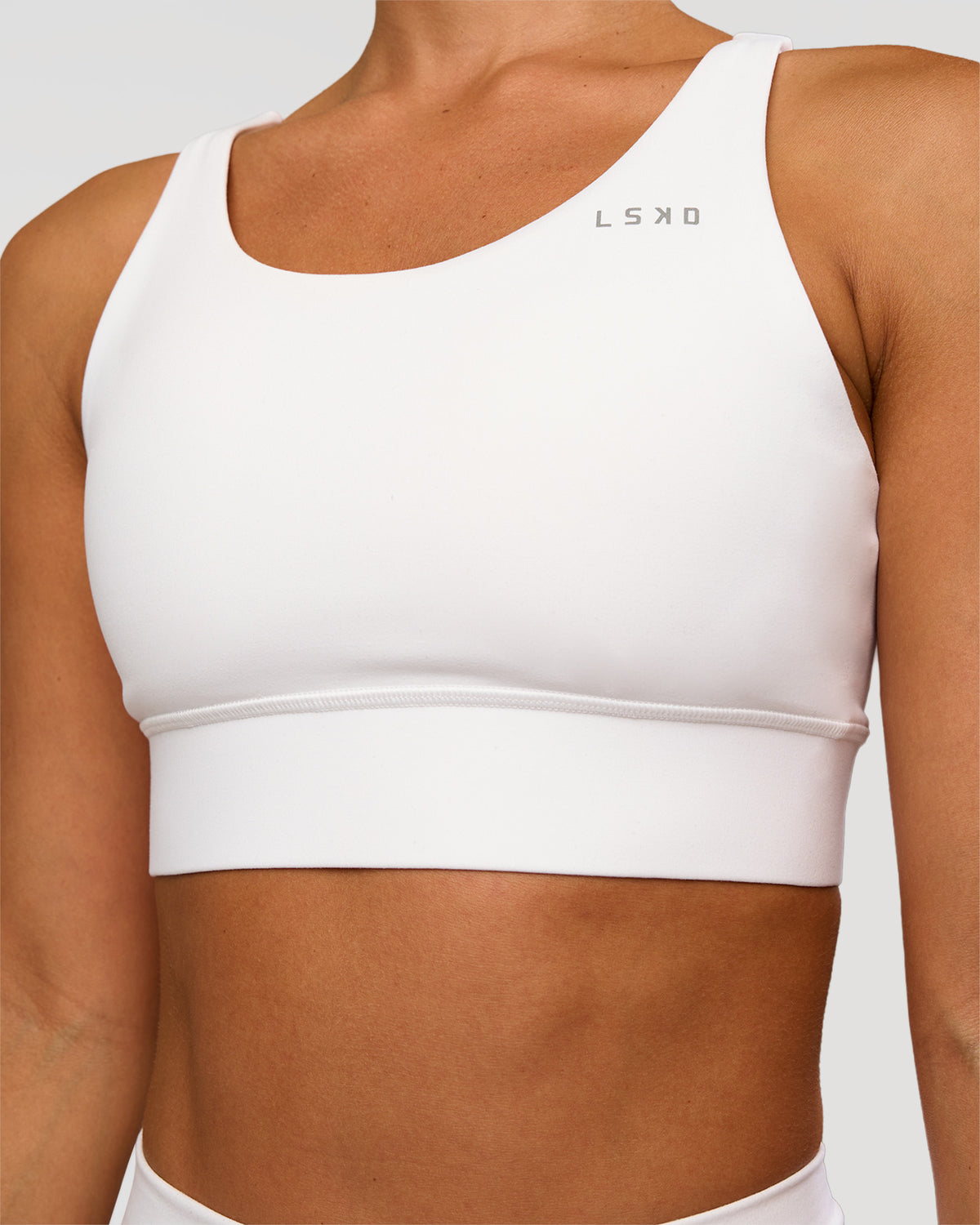 Woman wearing Accelerate Sports Bra - White | Set:true | Angle:closeup | Model:Brylee | Size:XS - view 1