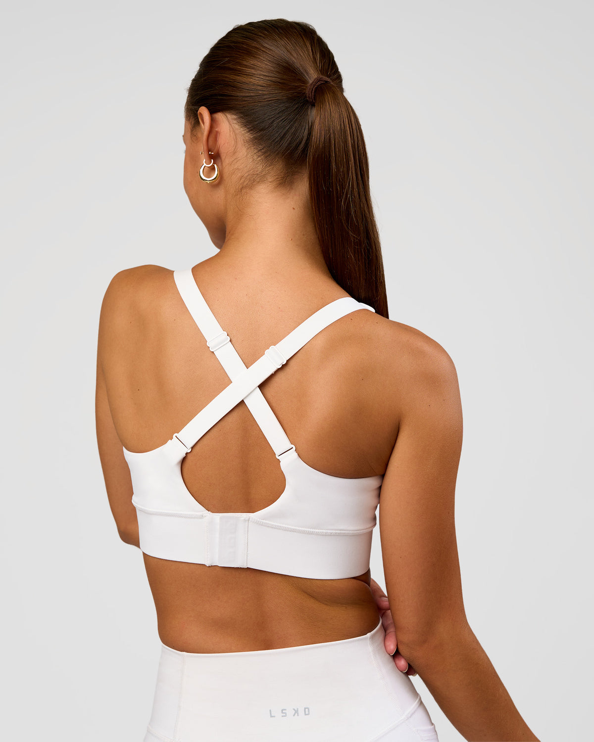 Woman wearing Accelerate Sports Bra - White | Set:true | Angle:back | Model:Brylee | Size:XS