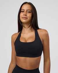 Woman wearing Aspire Sports Bra - Black | Model:Eliza | Size:XS | Thumbnail Index: 1