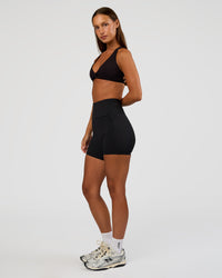 Woman wearing Aspire Twist Sports Bra - Black | Model:Brylee | Size:XS | Thumbnail Index: 2