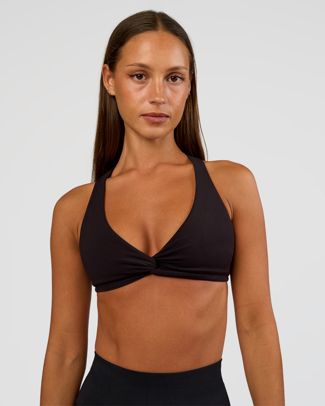 Woman wearing Aspire Twist Sports Bra - Black | Model:Brylee | Size:XS - view 1