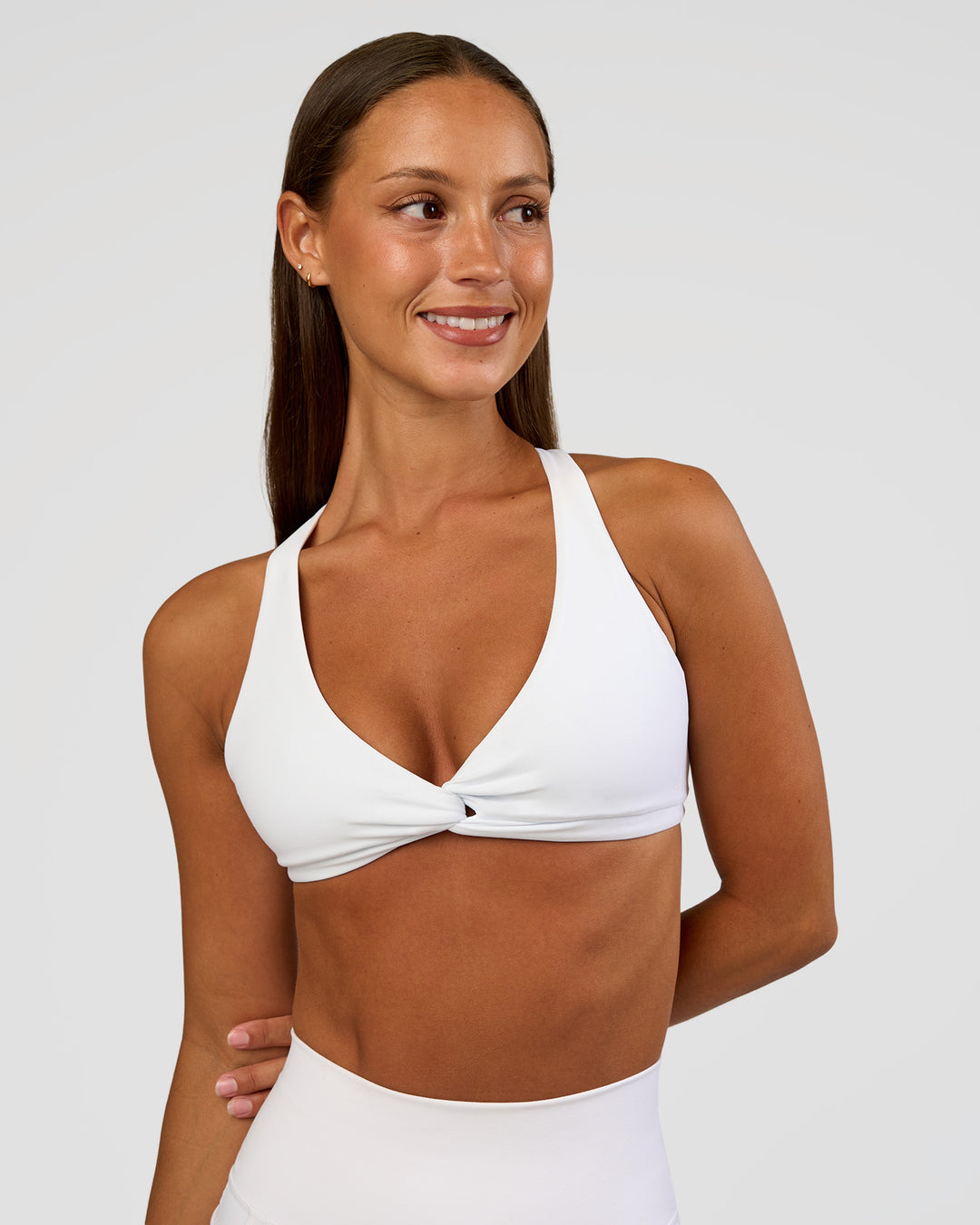 Woman wearing Aspire Twist Sports Bra - White | Model:Brylee | Size:XS - view 2